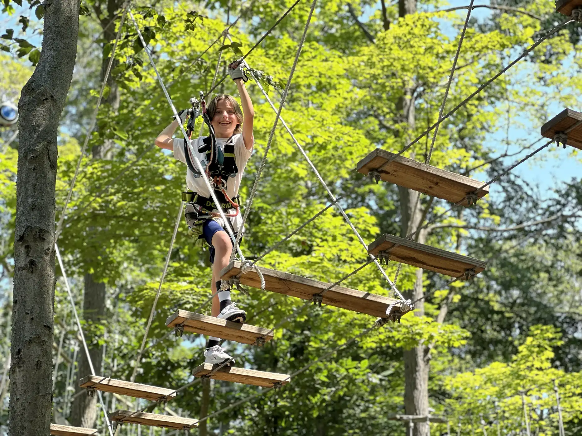Child enjoying obstacle course in the tree tops.