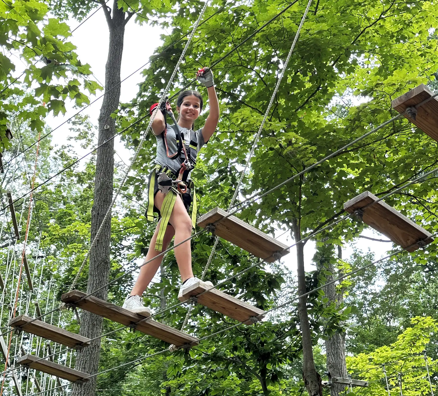 Teenage girl on obstacle course in the tree tops.