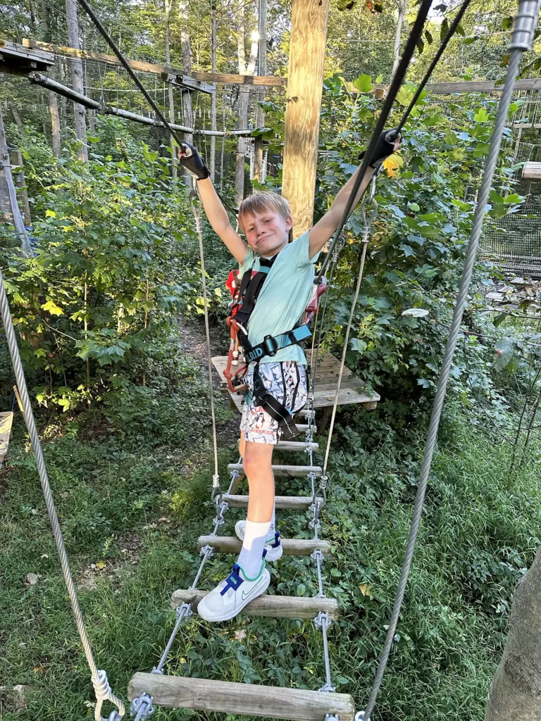 Boy striking a pose on aerial obstacle course