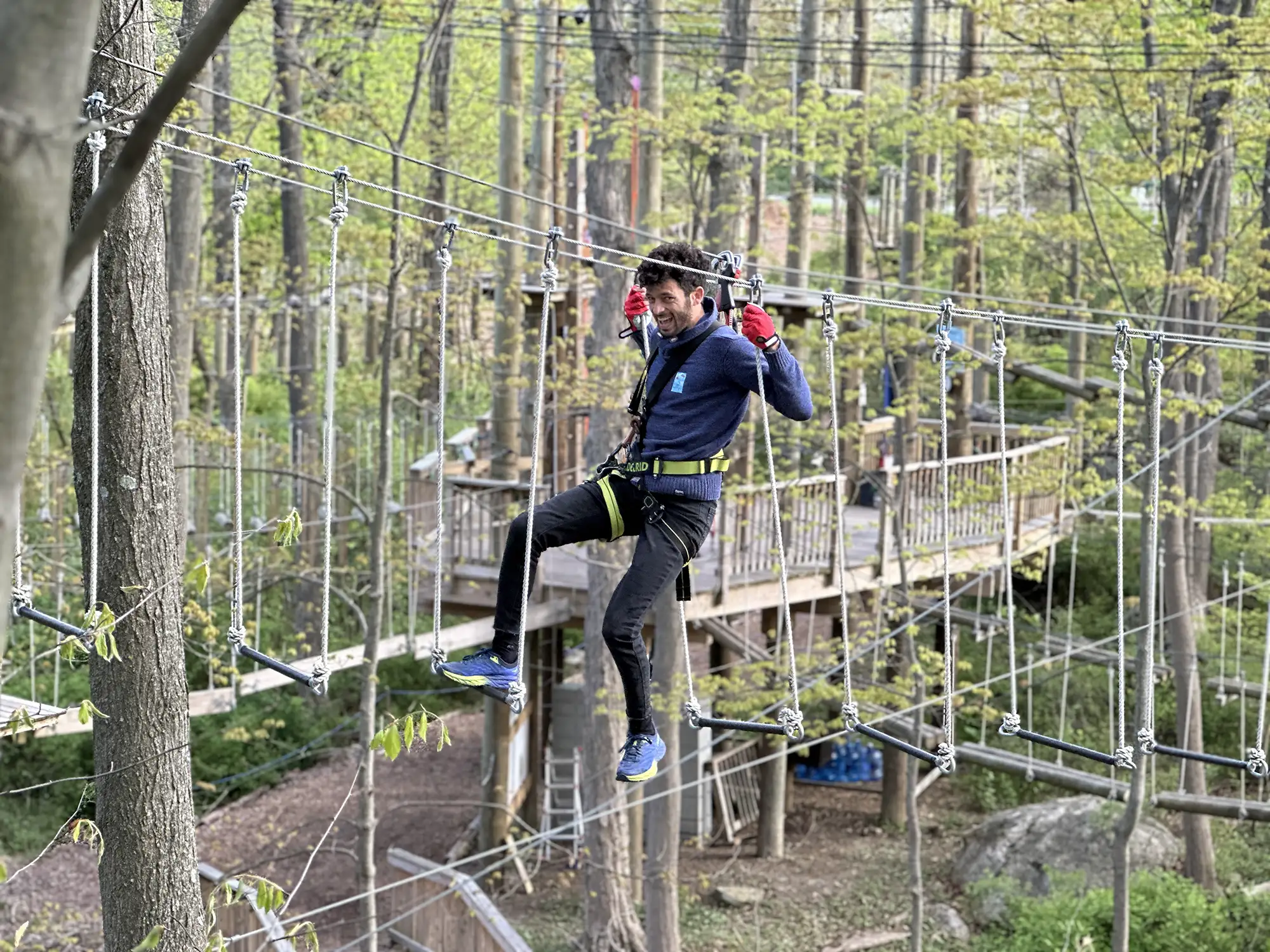 Man having fun on difficult tree top obstacle
